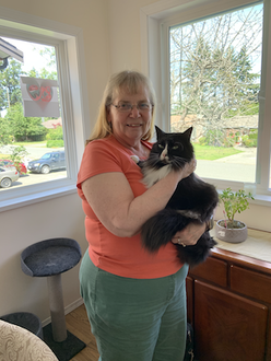 Diamond Mom with her cat standing in sun room.