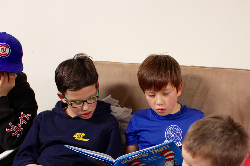 boys reading a book together